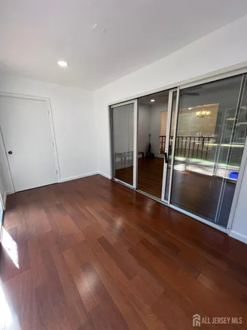an empty room with wooden floor and glass door