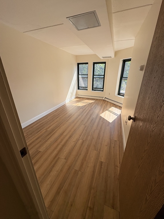 400 Massachusetts Avenue, Unit 34 Boston, MA 02115 - Photo 14 of 24 a view of an empty room with wooden floor and stairs
