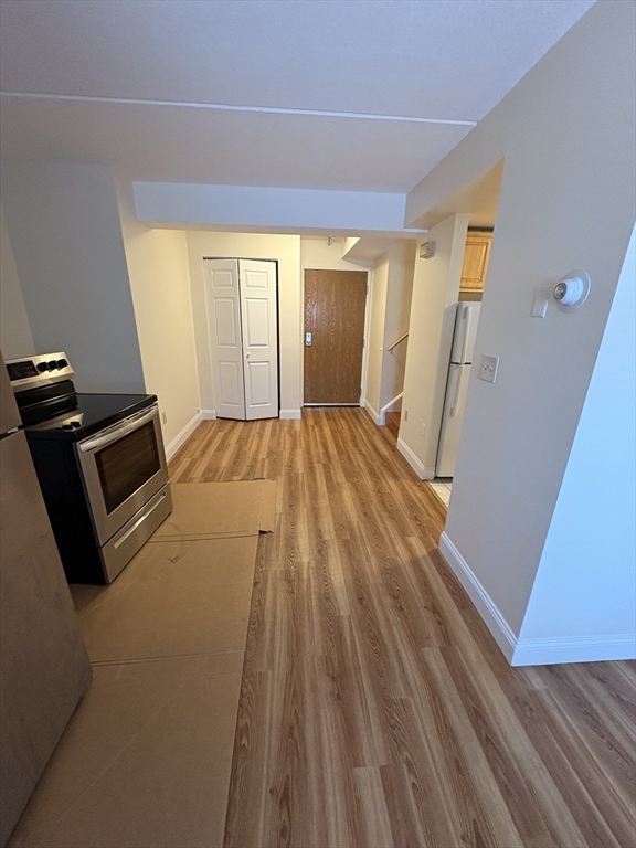 400 Massachusetts Avenue, Unit 34 Boston, MA 02115 - Photo 3 of 24 a view of an empty room with wooden floor and a window