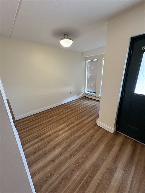 400 Massachusetts Avenue, Unit 34 Boston, MA 02115 - Photo 4 of 24 a view of an empty room with wooden floor and a window