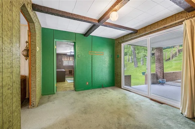 a view of house with wooden deck and outdoor space