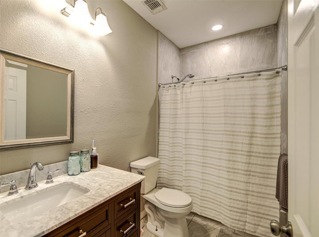 308 Cooke Street Nocona, TX 76255 - Photo 15 of 22 a bathroom with a granite countertop sink toilet and shower