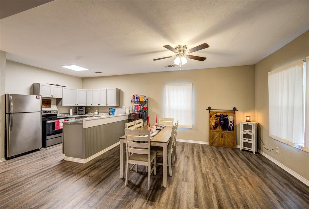 308 Cooke Street Nocona, TX 76255 - Photo 2 of 22 a dining room with furniture a kitchen wooden floor and a window