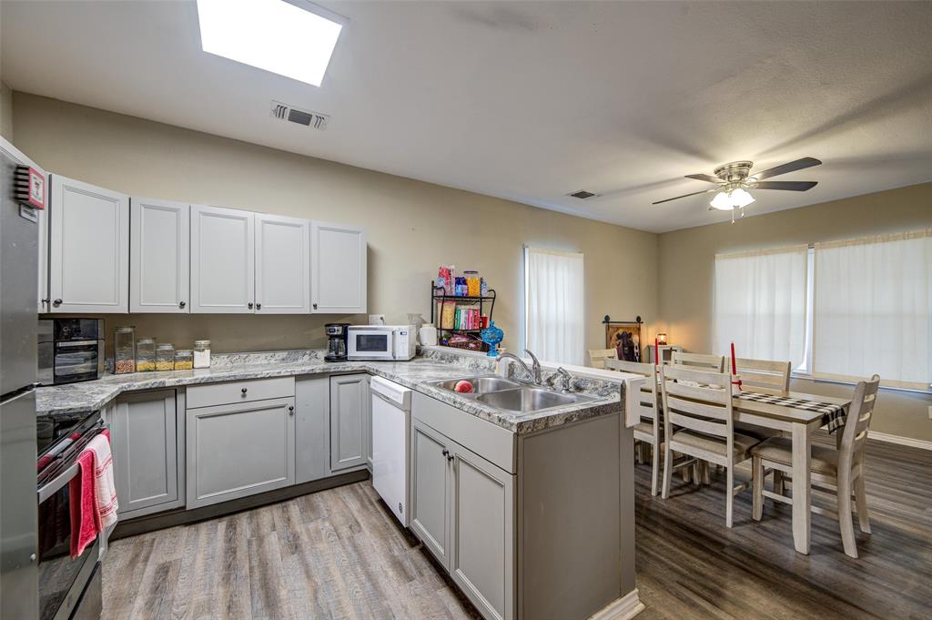 308 Cooke Street Nocona, TX 76255 - Photo 6 of 22 a kitchen that has a sink and a stove in it