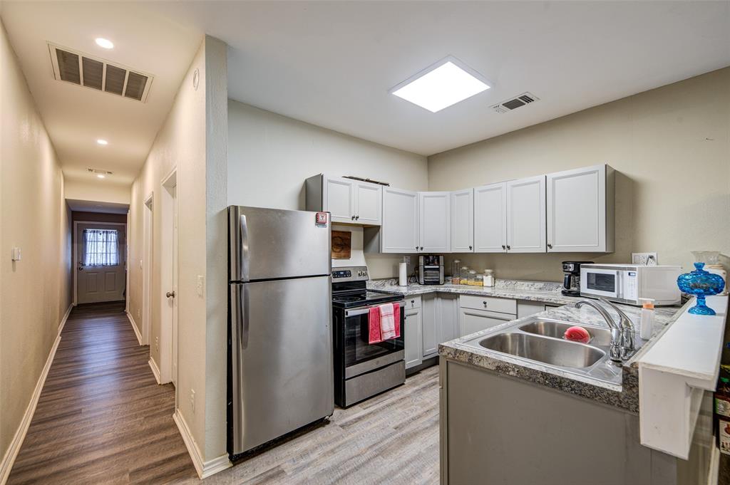308 Cooke Street Nocona, TX 76255 - Photo 7 of 22 a kitchen with a refrigerator a sink and dishwasher
