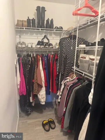 a view of walk in closet with clothes and shoes