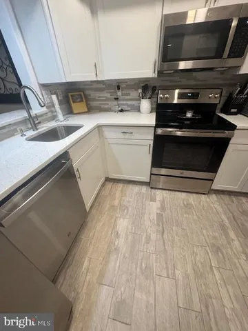 a kitchen with a stove and white cabinets