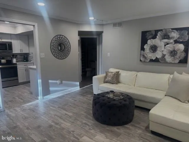a living room with furniture and a view of kitchen