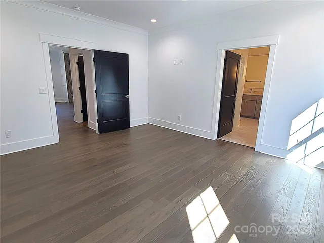 an empty room with wooden floor and mirror