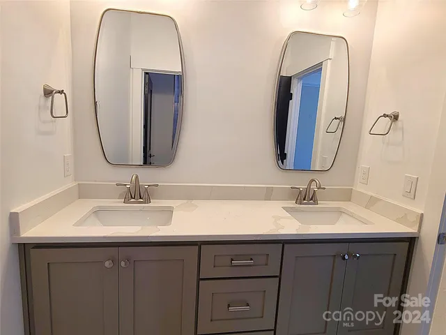 a bathroom with a double vanity sink and a mirror