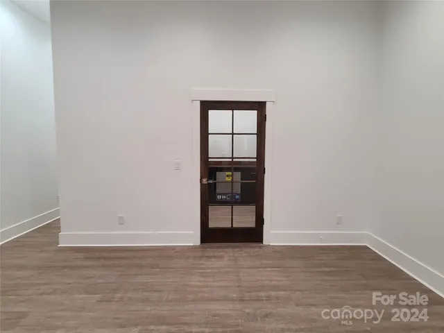 a view of an empty room with wooden floor and cabinet