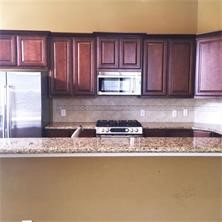 1824 Wichita Street, Unit B Houston, TX 77004 - Photo 5 of 18 a kitchen with granite countertop a sink a stove and cabinets
