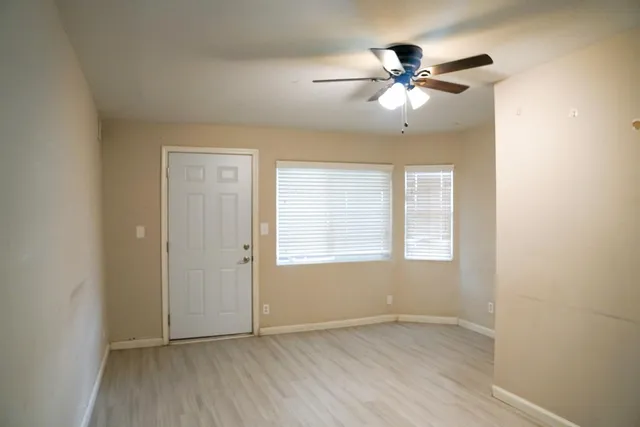 an empty room with fan and windows