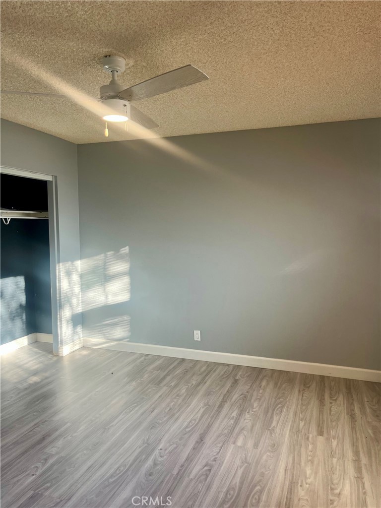 16535 Pine Street, Unit B Hesperia, CA 92345 - Photo 20 of 22 a view of an empty room with wooden floor