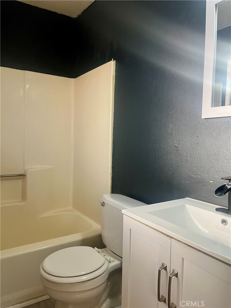 16535 Pine Street, Unit B Hesperia, CA 92345 - Photo 21 of 22 a white toilet sitting next to a bathroom sink and tub