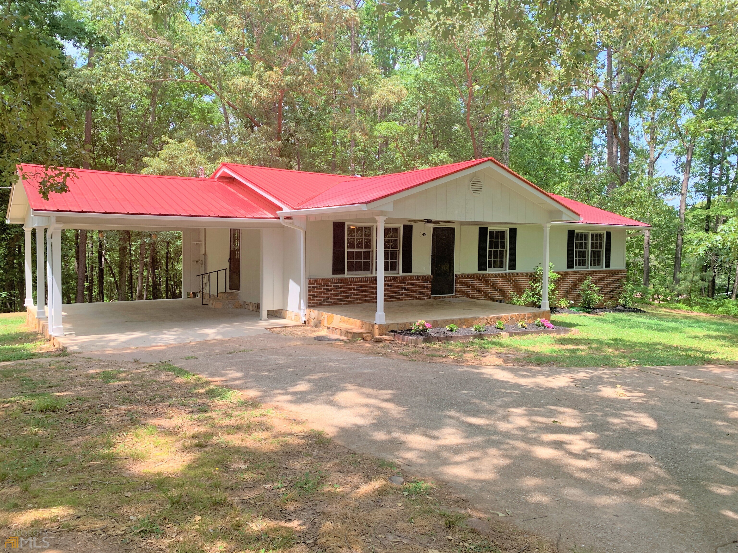 a front view of a house with a yard and trees