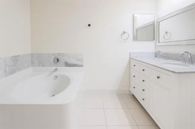 a bathroom with a bathtub sink and mirror