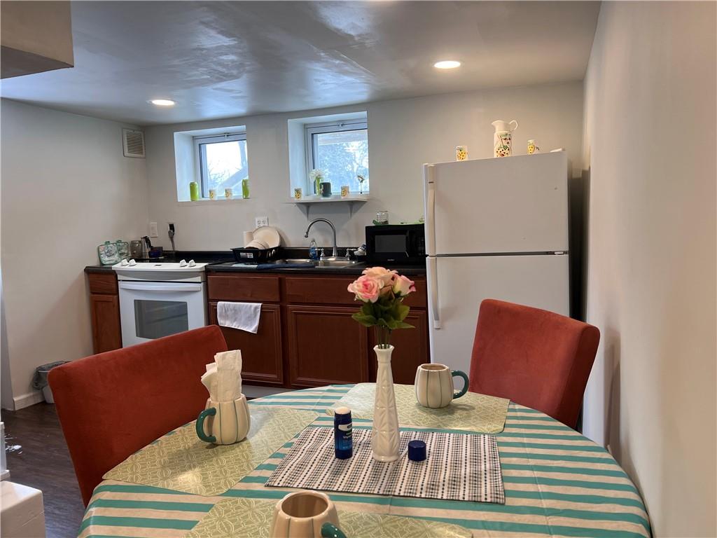 61 Pointview Road Pittsburgh, PA 15227 - Photo 3 of 12 a kitchen with stainless steel appliances granite countertop a dining table chairs and a refrigerator