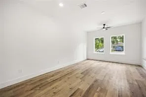 an empty room with windows and ceiling fan
