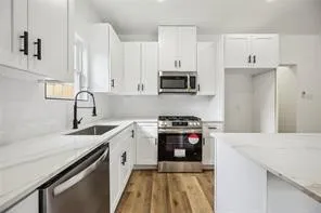 a kitchen with stainless steel appliances granite countertop a sink stove and refrigerator