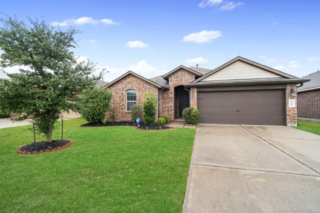 a front view of a house with a yard and a garage