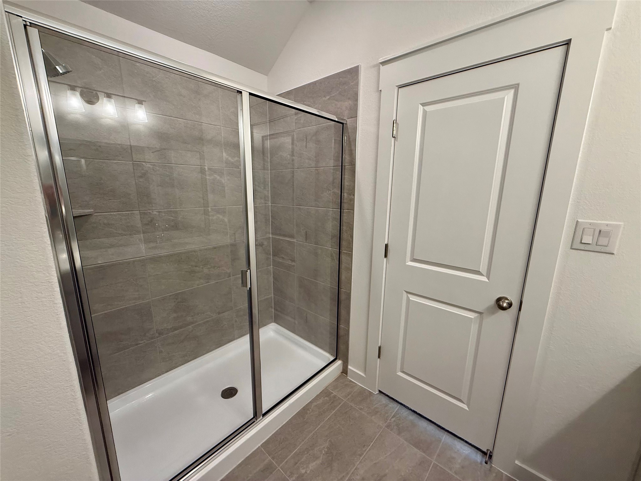 13605 Barn Chime Street Elgin, TX 78621 - Photo 11 of 20 a bathroom with a glass shower door