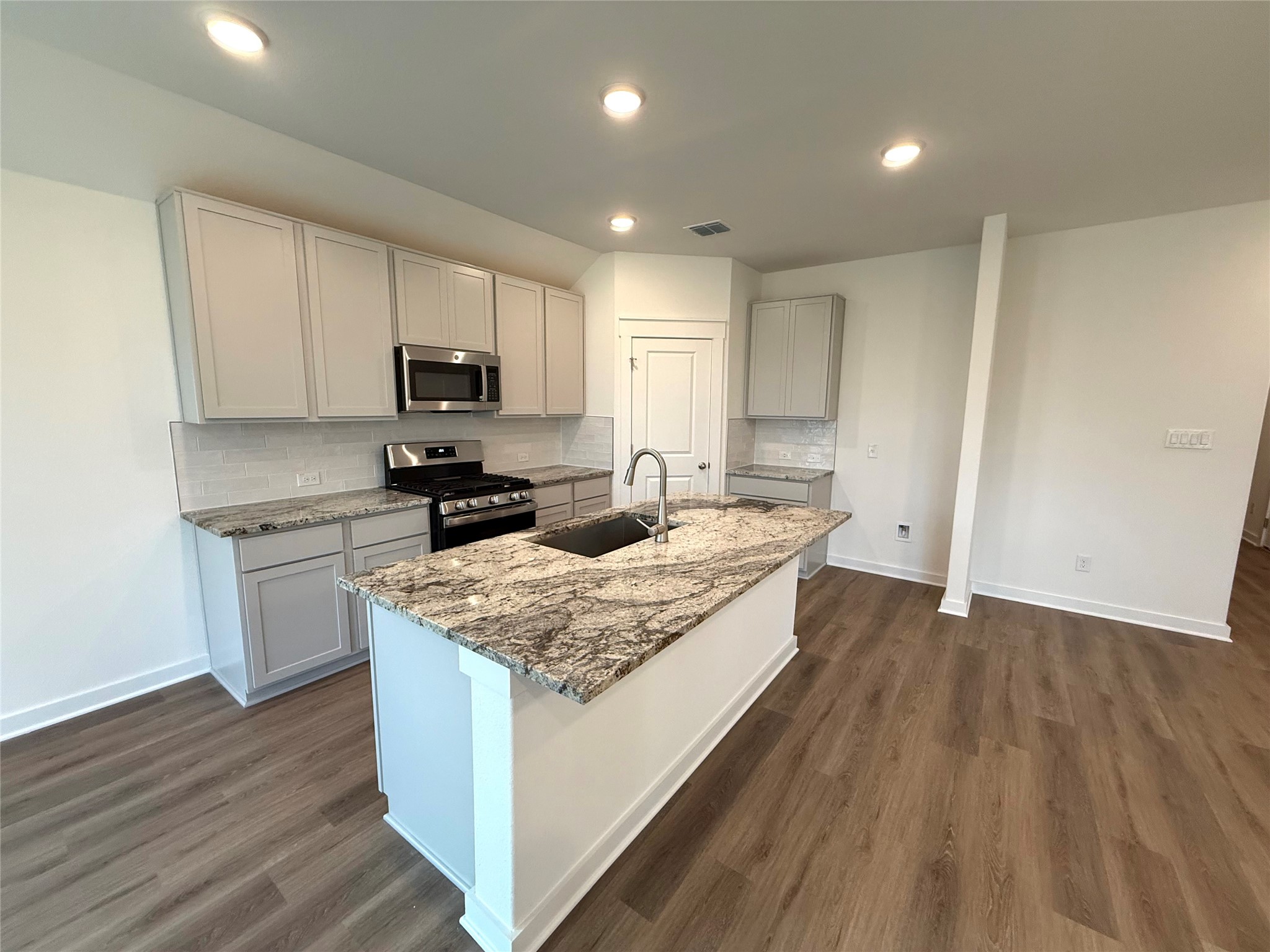 13605 Barn Chime Street Elgin, TX 78621 - Photo 2 of 20 a kitchen with a sink stove and microwave