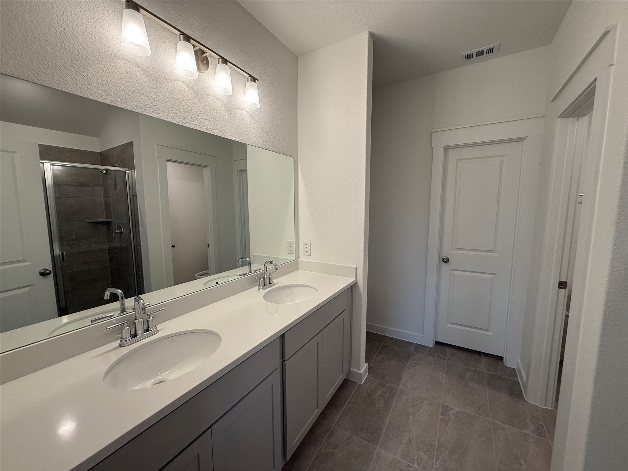 13605 Barn Chime Street Elgin, TX 78621 - Photo 10 of 20 a bathroom with a double vanity sink and a mirror