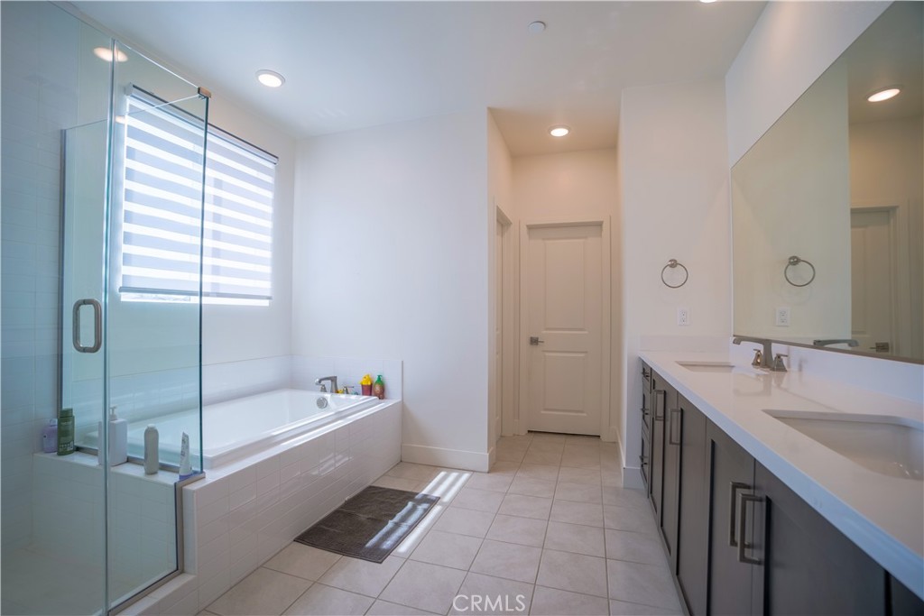 35323 Orchard Trail Fallbrook, CA 92028 - Photo 14 of 30 a bathroom with a tub a sink and mirror
