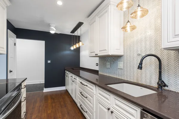 a kitchen with granite countertop a sink stainless steel appliances and cabinets