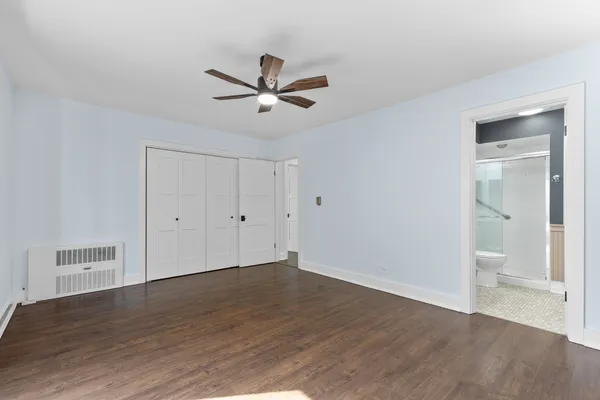a view of a room with wooden floor and a ceiling fan