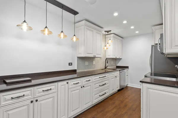 a kitchen with granite countertop white cabinets and white appliances
