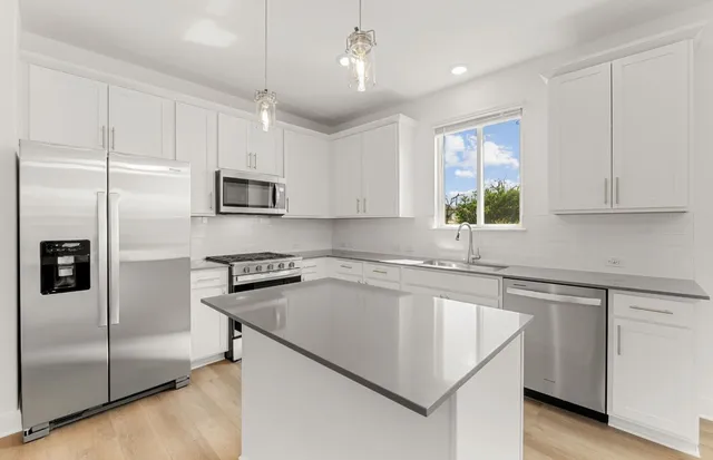 a kitchen with stainless steel appliances kitchen island granite countertop a sink and cabinets