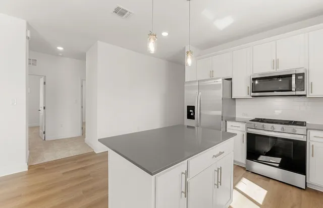 a kitchen with a sink a counter top space stainless steel appliances and a window