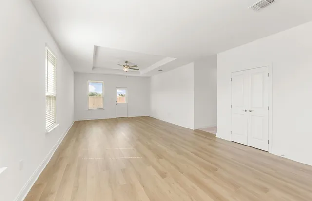 a view of a room with wooden floor and ceiling fan