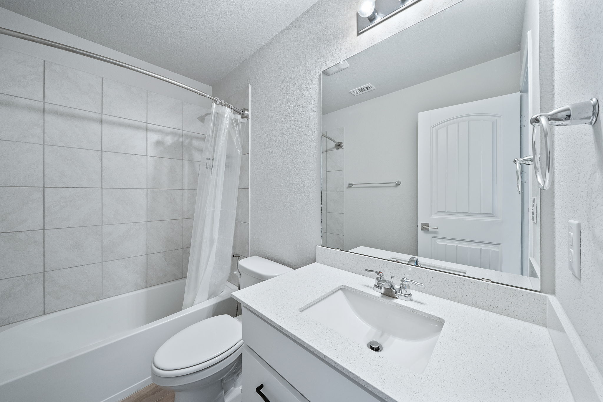 2412 Starhill Ranch Street Georgetown, TX 78628 - Photo 34 of 40 A pristine bathroom featuring a clean white vanity and a spacious tub-shower combination.