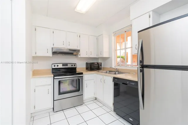 a kitchen with stainless steel appliances granite countertop a refrigerator a sink a stove a microwave and cabinets