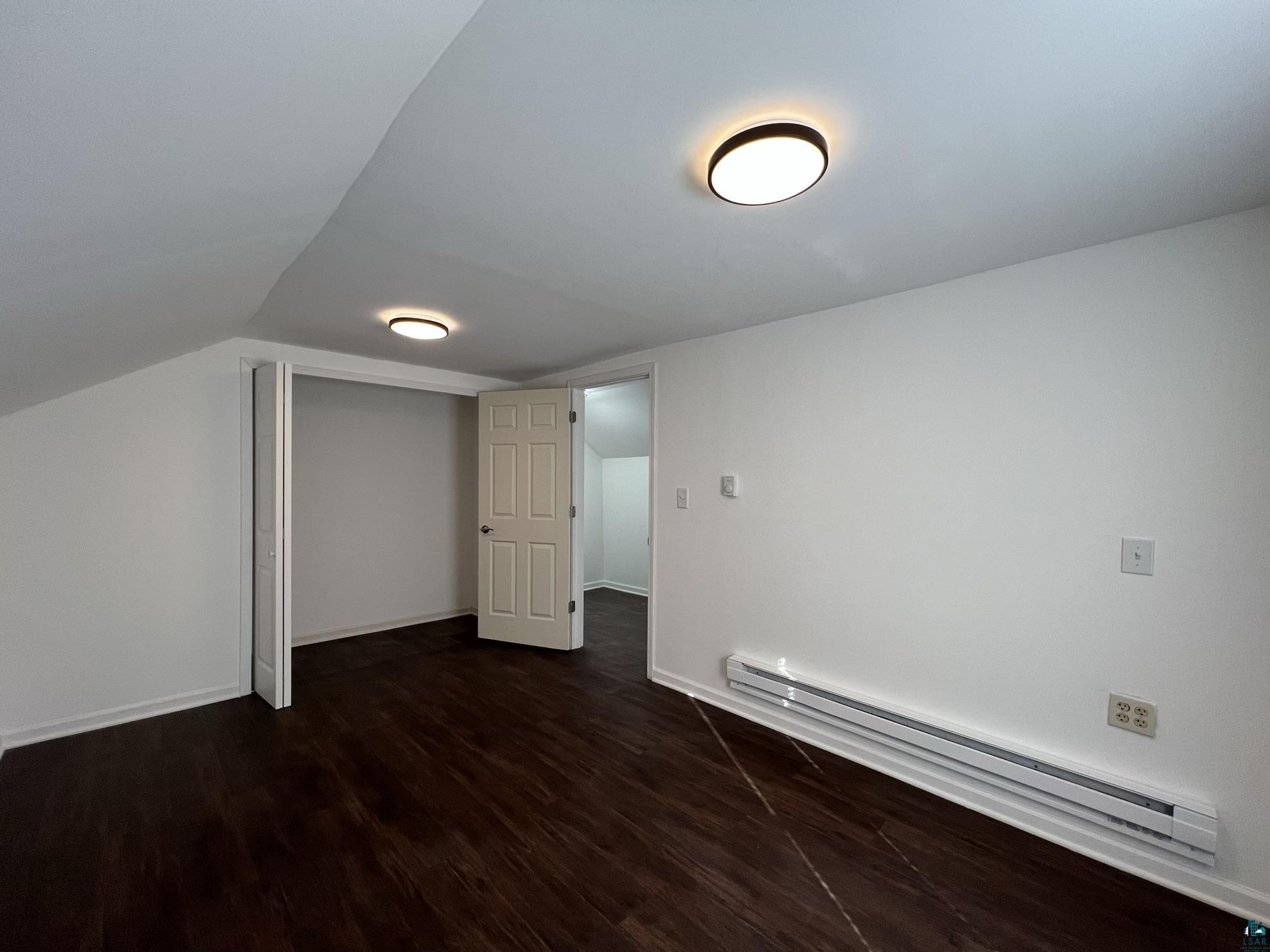 306 7th Street West Ashland, WI 54806 - Photo 20 of 25 Bonus room featuring a baseboard heating unit and dark wood finished floors