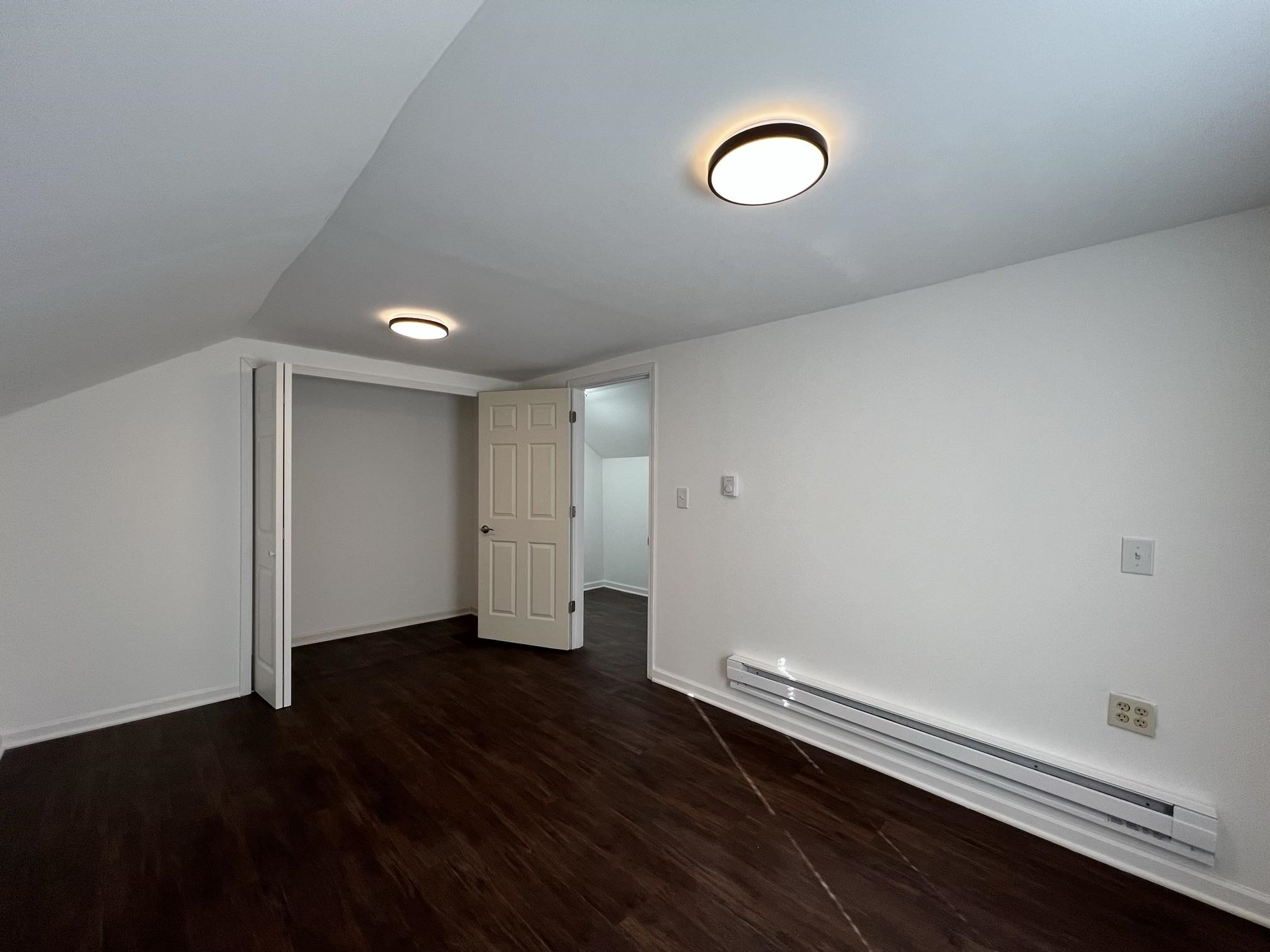 306 7th Street West Ashland, WI 54806 - Photo 20 of 25 Bonus room featuring a baseboard heating unit and dark wood finished floors