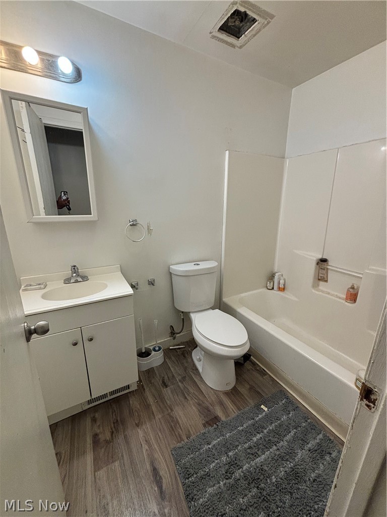 10014 Reno Avenue Cleveland, OH 44105 - Photo 8 of 11 Full bathroom with vanity, bathtub / shower combination, toilet, and hardwood / wood-style floors