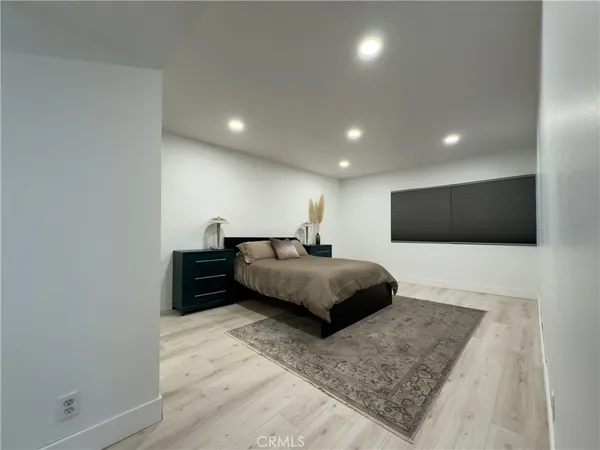 a spacious bedroom with a bed and a television