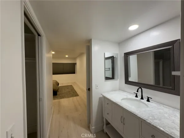a en suite bathroom with a granite countertop sink and mirror
