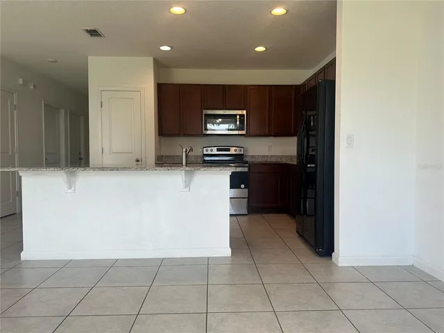 a kitchen with stainless steel appliances granite countertop a refrigerator and a stove