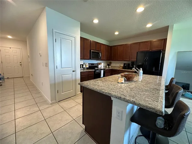 a kitchen with stainless steel appliances granite countertop a sink and a refrigerator