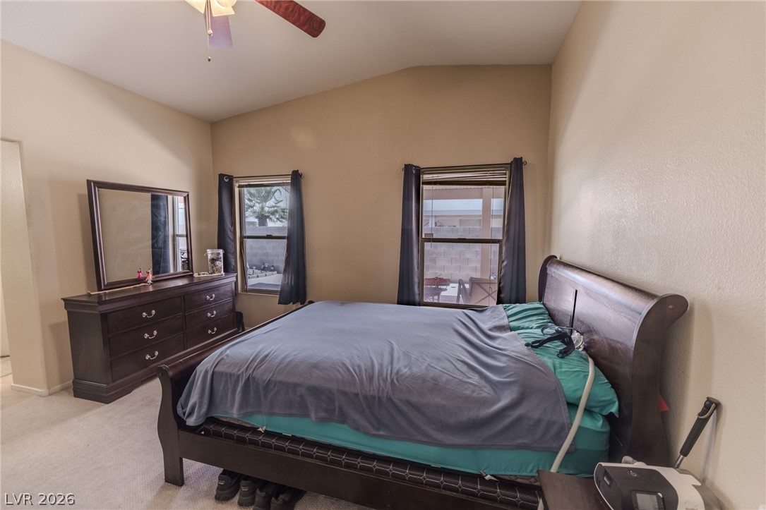 4994 Mascaro Drive Las Vegas, NV 89122 - Photo 15 of 30 Relax in this well-lit bedroom featuring vaulted ceilings and comfortable carpeting.