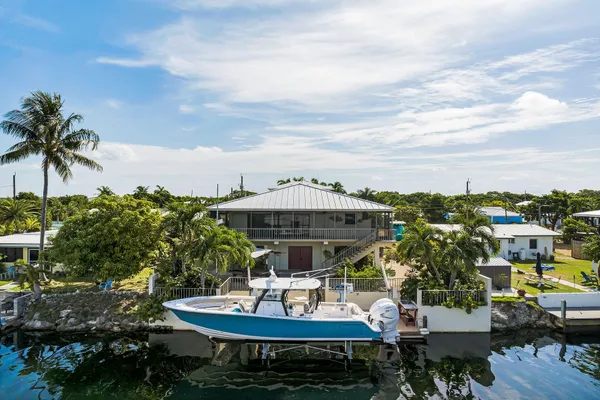 a view of a house with backyard sitting area and swimming pool