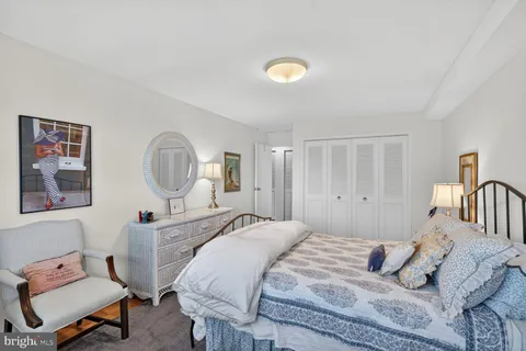 a bedroom with a bed a dresser and chair