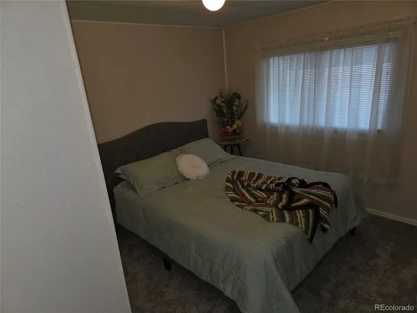a bed sitting in a bedroom next to a window