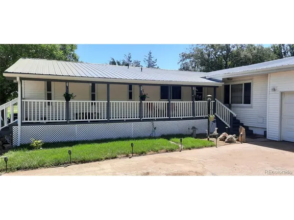 a view of a house with a small yard and wooden fence