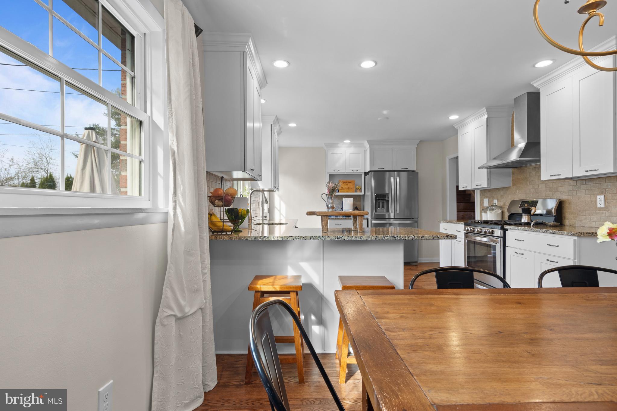 502 Ridge Avenue Kennett Square, PA 19348 - Photo 19 of 60 a kitchen with stainless steel appliances granite countertop a refrigerator a sink dishwasher a stove and white countertops with wooden floor